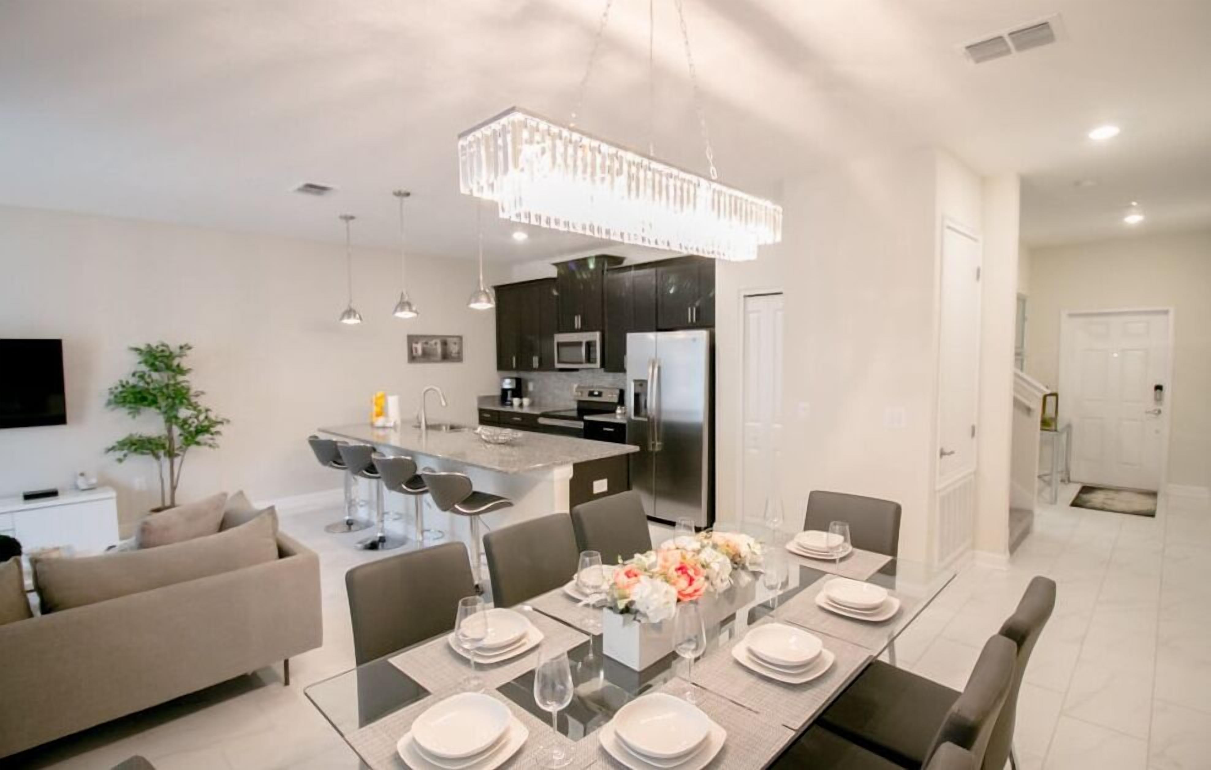 A modern kitchen with dark cabinets, stainless steel appliances, and a central island.