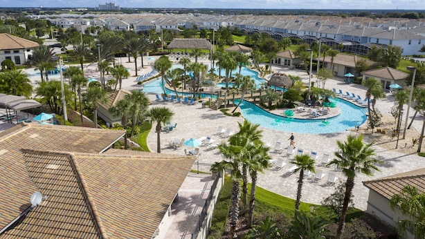 A resort with a large pool area, multiple lounge chairs, and palm trees. - Last Minute Disney Getaway! Villa with Private Pool & Hot Tub. Book Now! #43253 (Orlando)