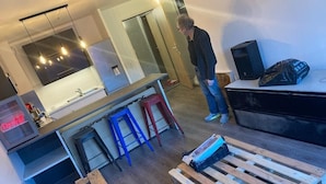 Eine moderne Küche mit Einbauofen, einem großen Fenster und einem Essbereich mit Holztisch.