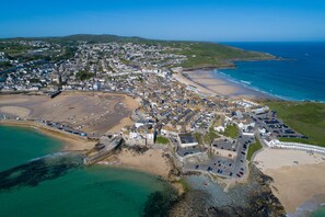An aerial view of a coastal town with a beach, a marina, and a mix of residential and commercial buildings. - Mariners Cottage, St Ives -  a cottage that sleeps 6 guests  in 3 bedrooms (St Ives)