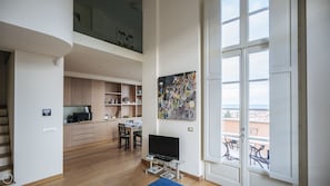 Enjoy a spacious living area with a mezzanine level, large window, and flat-screen TV.
