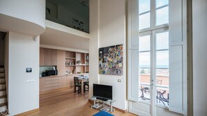 A spacious living area with a dining table, a TV, and a balcony with outdoor furniture. - Virgilio 2 - Villa Bice (Alassio)