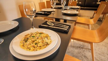A dining table set with plates, cutlery, and a glass of water.