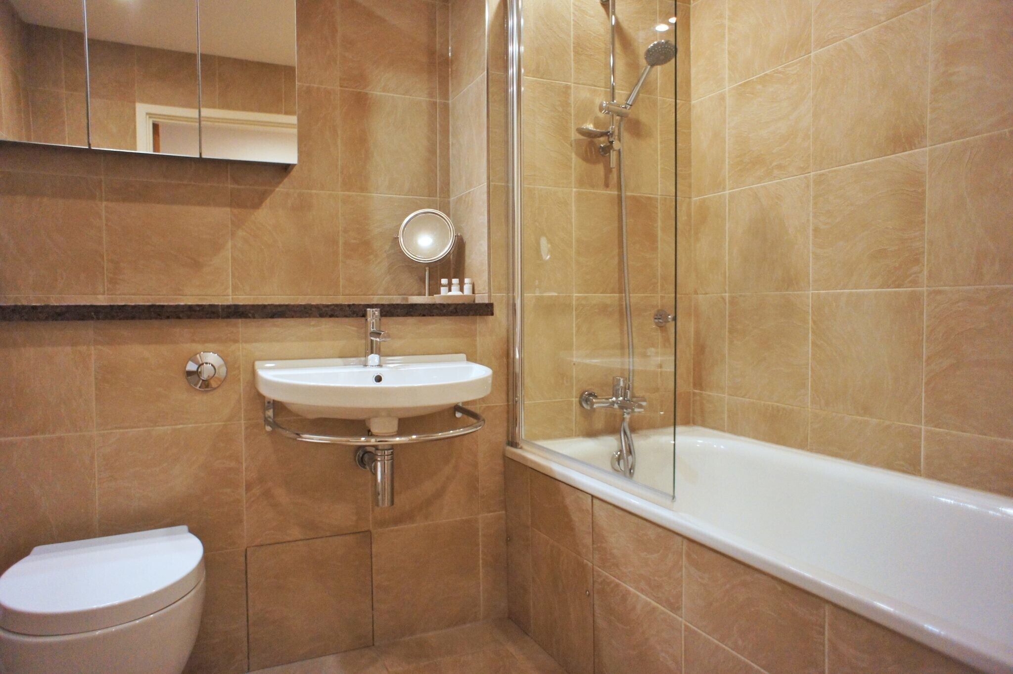 A bathroom with a toilet, sink, and bathtub.
