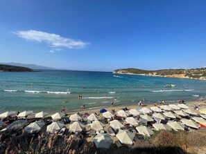 A beach with umbrellas and people.