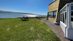 Un bâtiment situé au bord du lac, doté d’un patio avec des tables de pique-nique.