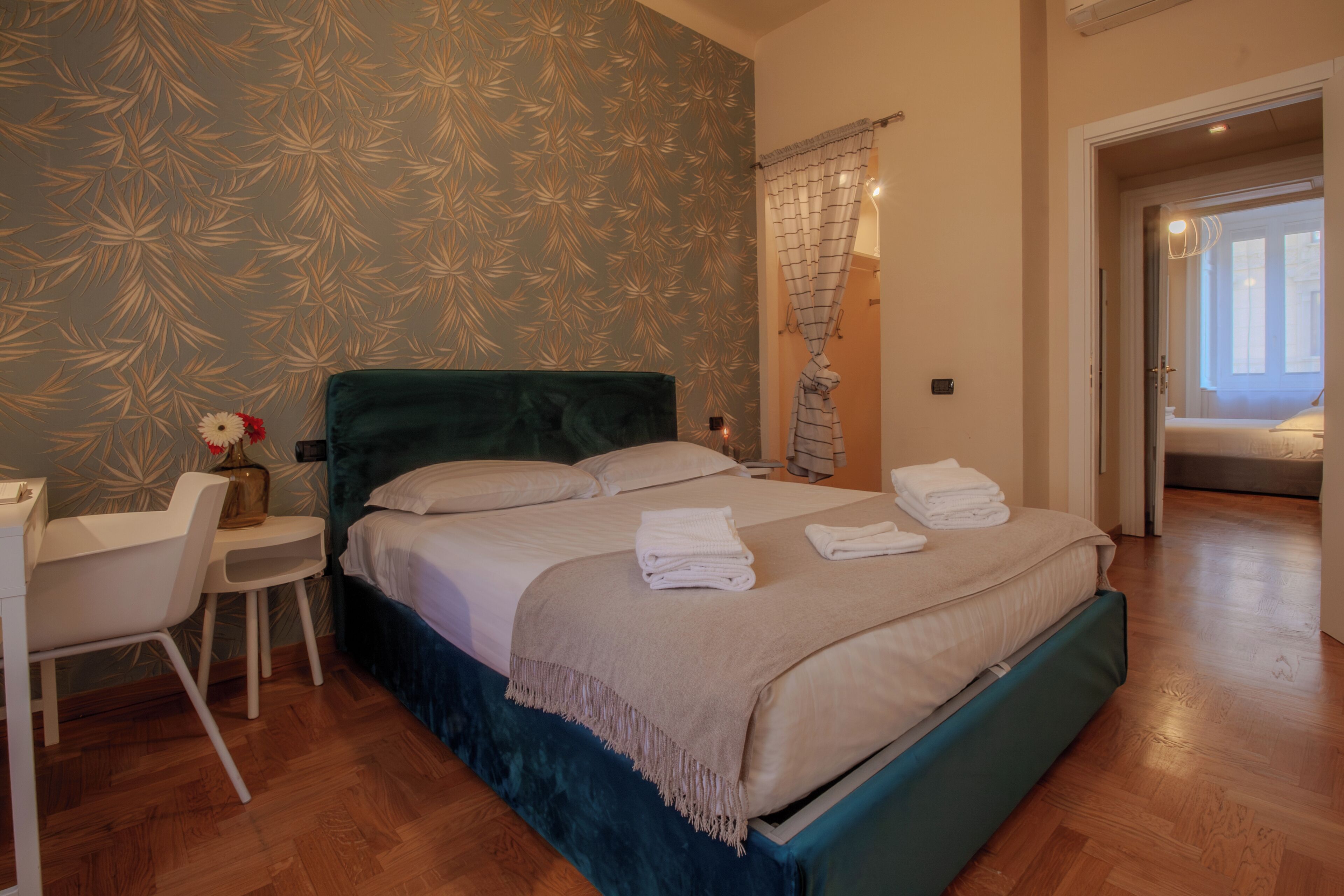 A bedroom with a bed, a desk, and a chair.