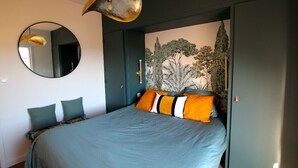 A bedroom with a bed, a round mirror, and a mural of trees on the wall. - Very Nice 60m² With Balcony Near The Beaches! (Six-Fours-les-Plages)