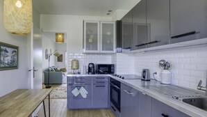 A modern kitchen with grey cabinets, a microwave, a kettle, and a hanging light fixture. - Very Nice 60m² With Balcony Near The Beaches! (Six-Fours-les-Plages)