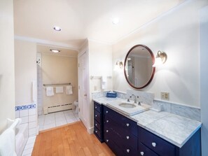A bathroom with a sink, mirror, and dark cabinets. - Renovated, Five Bedrooms In Historic Williamstown (Williamstown)