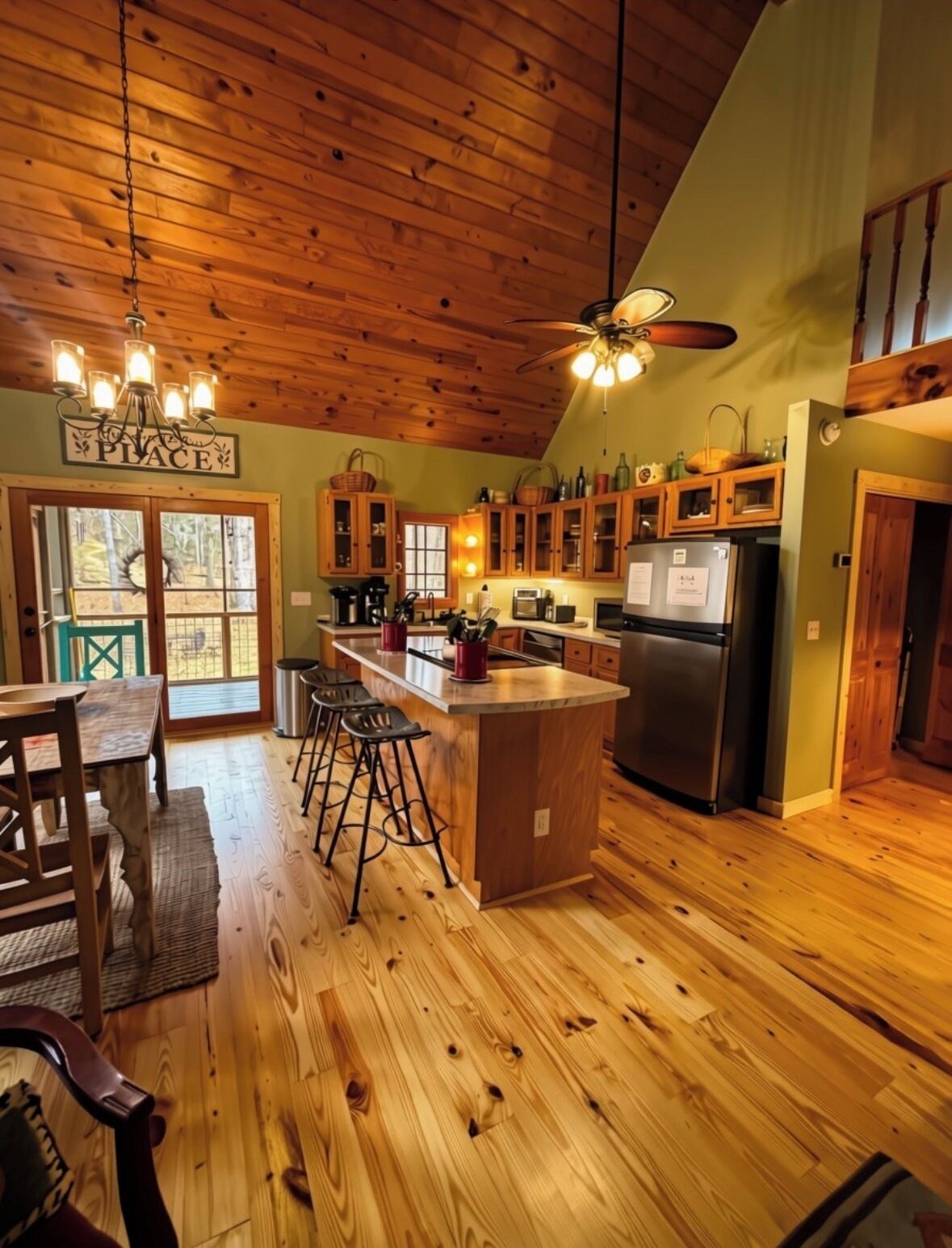 A kitchen with wooden floors, a bar area, and a ceiling fan.