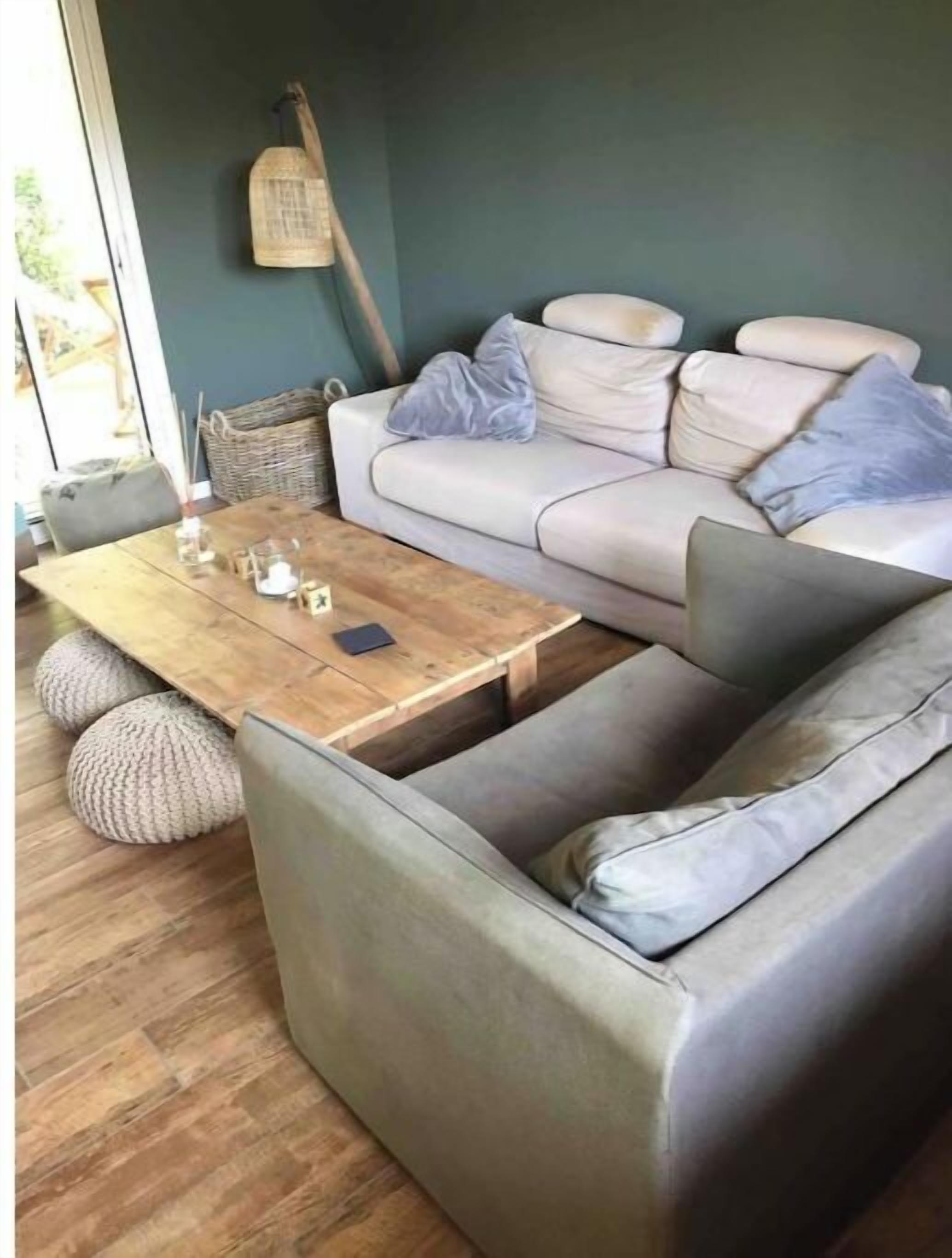 A modern living room with a grey sofa, a wooden coffee table, and a wicker basket.