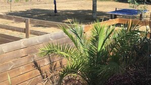 An outdoor area with a volleyball net, a wooden fence, and some greenery. - Maison Cocooning Proche Plages (Soustons)