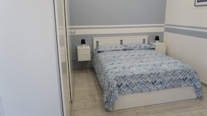 A bedroom with a bed, two bedside tables, and a nightstand.