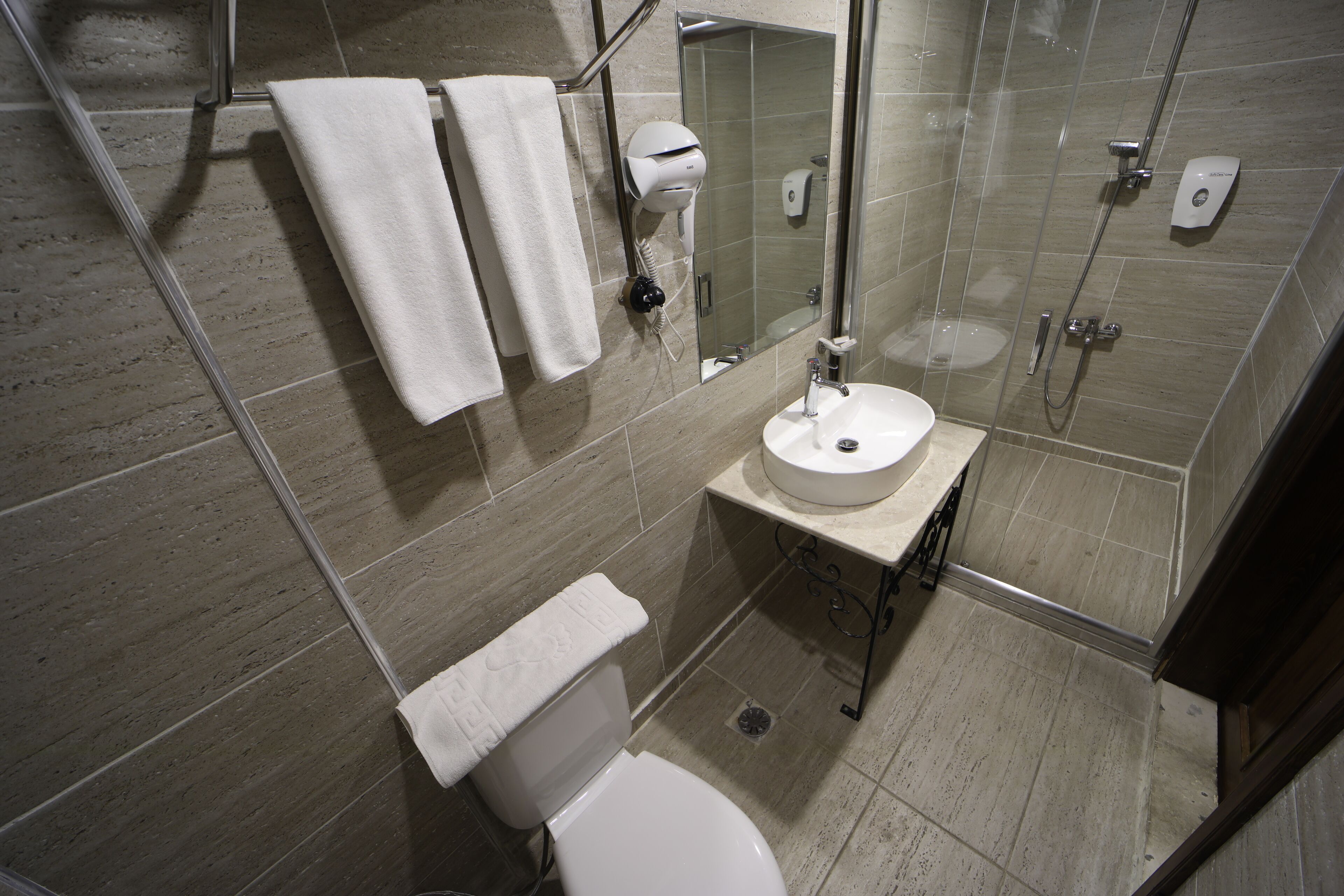A modern bathroom with a toilet, sink, and shower.