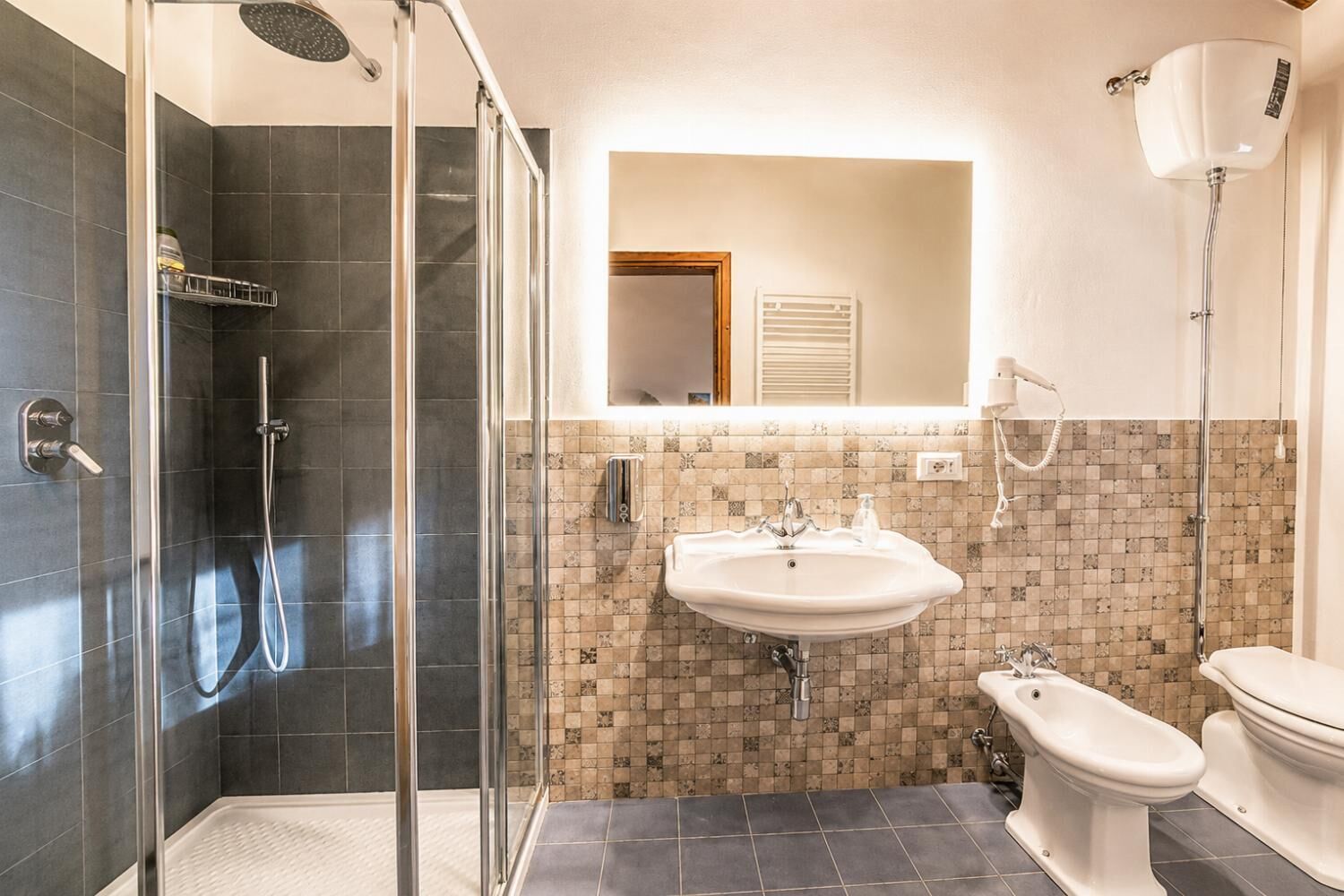A modern bathroom with a glass-enclosed shower, a white sink, and a toilet.