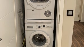Lavadora y secadora apiladas en un cuarto de lavado.