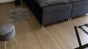 Un dormitorio moderno con una cama grande, un cabecero acolchado y un muro de listones de madera.