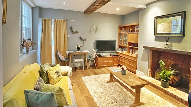 Een woonkamer met een bank, een salontafel, een open haard en een televisie.