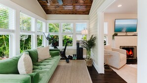 Ein Wohnzimmer mit einem grünen Sofa, einem Heimtrainer und einem Kamin.