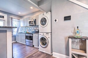 A compact kitchen with a double washer, a microwave, and a built-in oven. - 6 Mi to Inner Harbor - Family Home w/ Fenced Yard! (Baltimore)