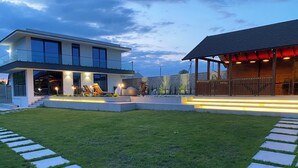 Une maison moderne dotée d’une pelouse bien entretenue et d’un espace patio.