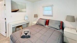 Ein Schlafzimmer mit einem Bett, einem Schreibtisch und einem Stuhl.