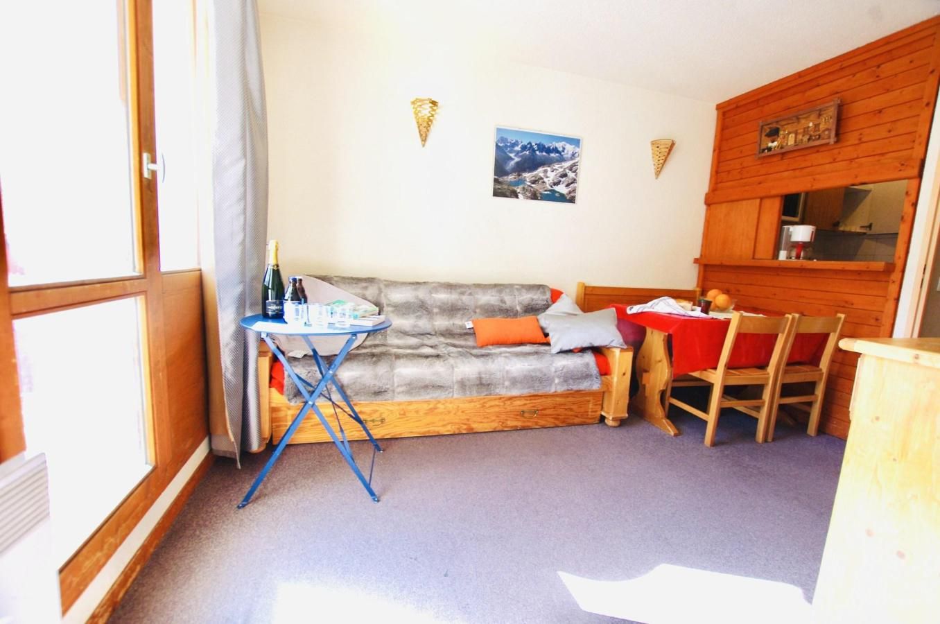 A cozy room with a sofa, a small table, and a wooden cabinet.