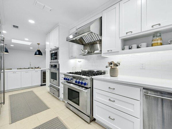 Enjoy cooking in this well-equipped kitchen with a gas stove, oven, microwave, and range hood.