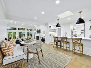 Relax in this stylish space with a large dining table, comfortable sofa, and modern kitchen area.