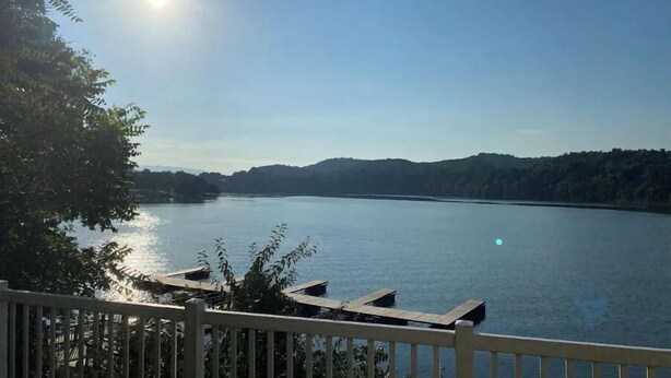 A lake with a wooden dock and a clear sky. - Sunrise Deck and Boat Slip. Peace and Fun!  (Johnson City)