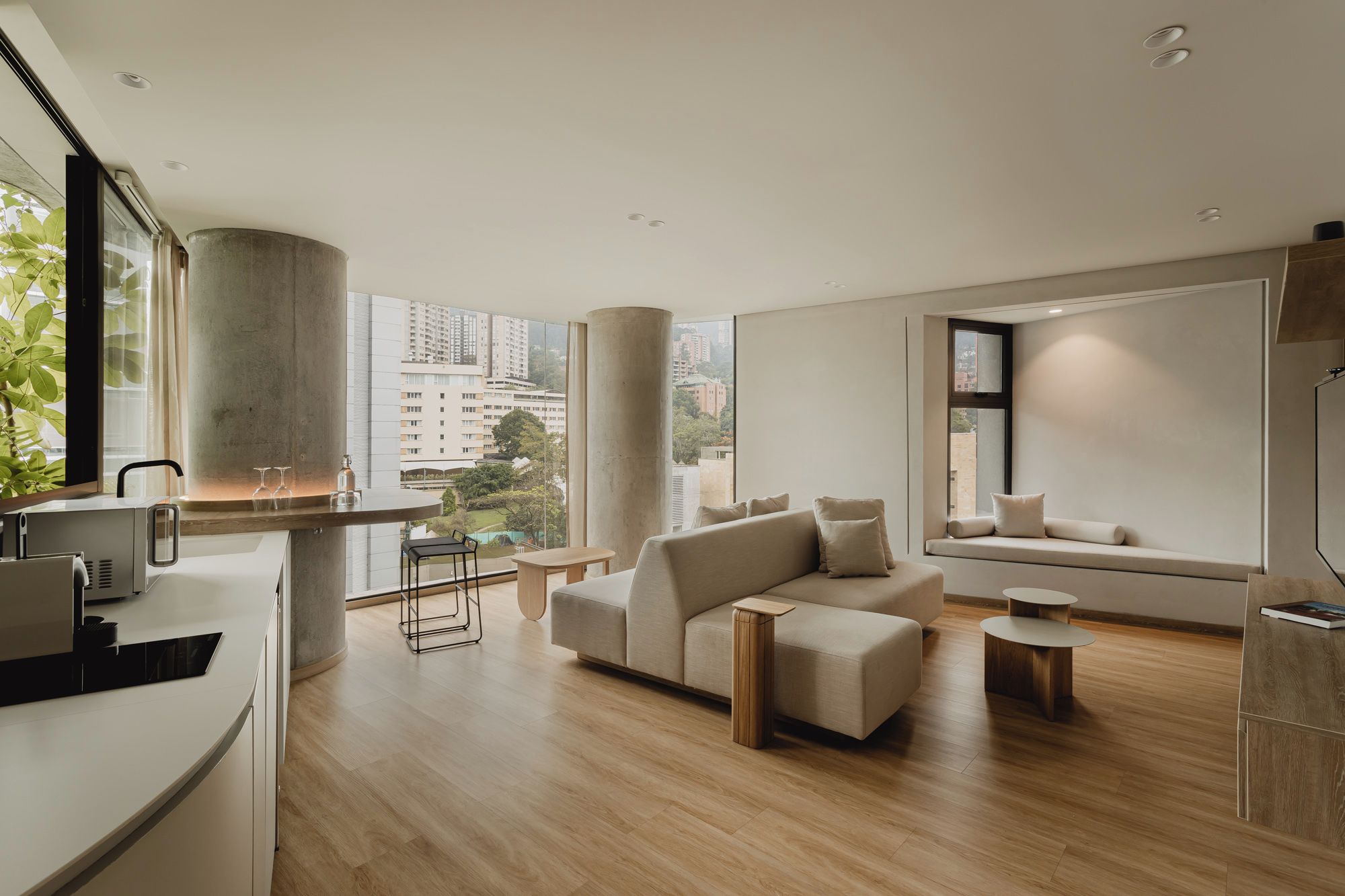 A modern living room with a sofa, a coffee table, and a dining area with a bar.