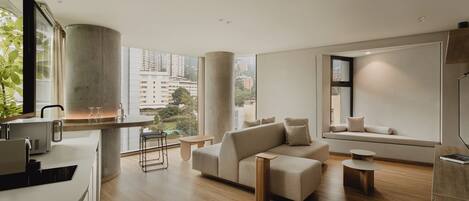 A modern living room with a sofa, a coffee table, and a dining area with a bar.