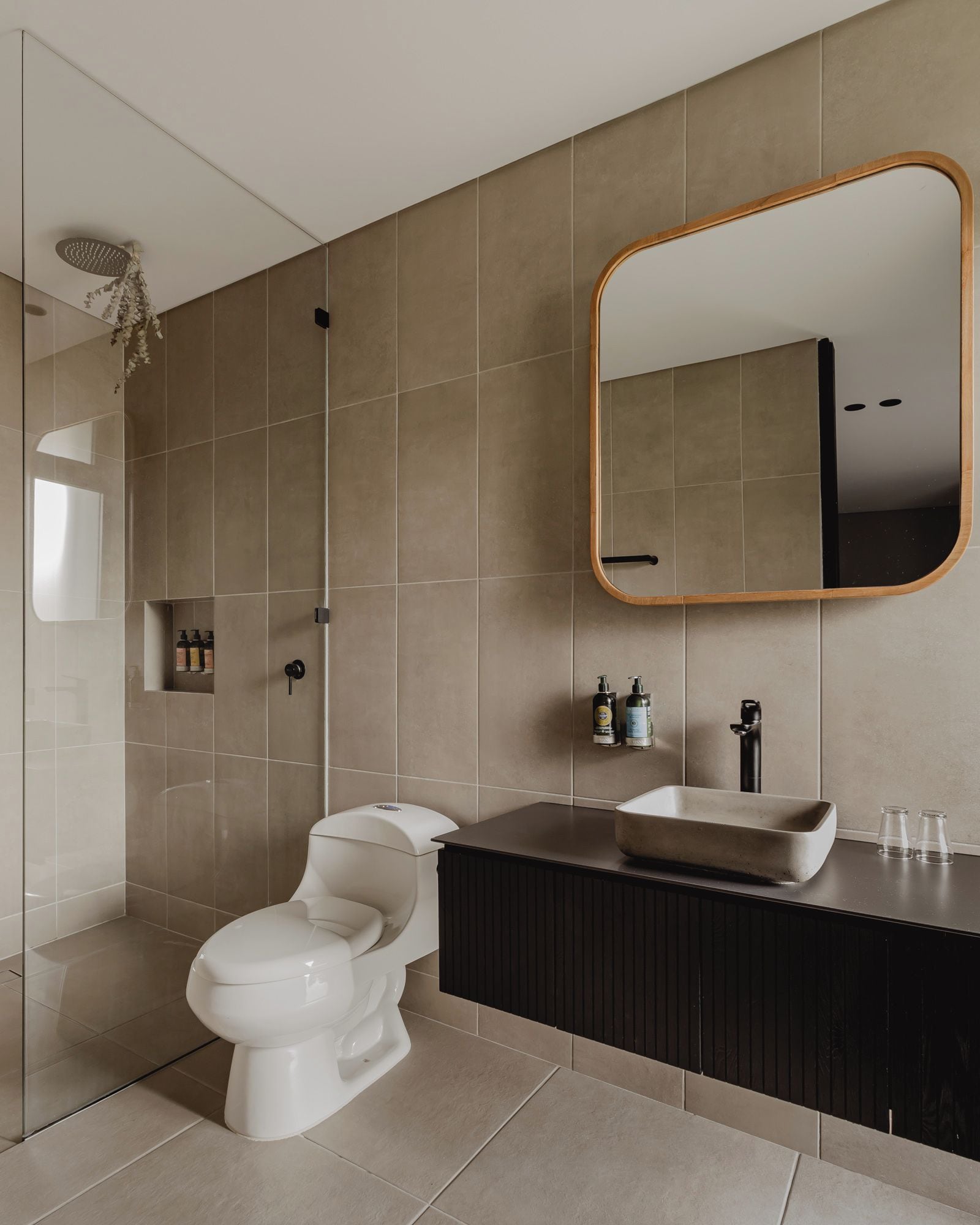 Un baño moderno con inodoro, lavabo y ducha.