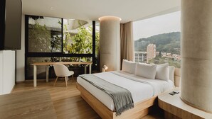 Una camera da letto moderna con un letto grande, una scrivania e vista sulla città.