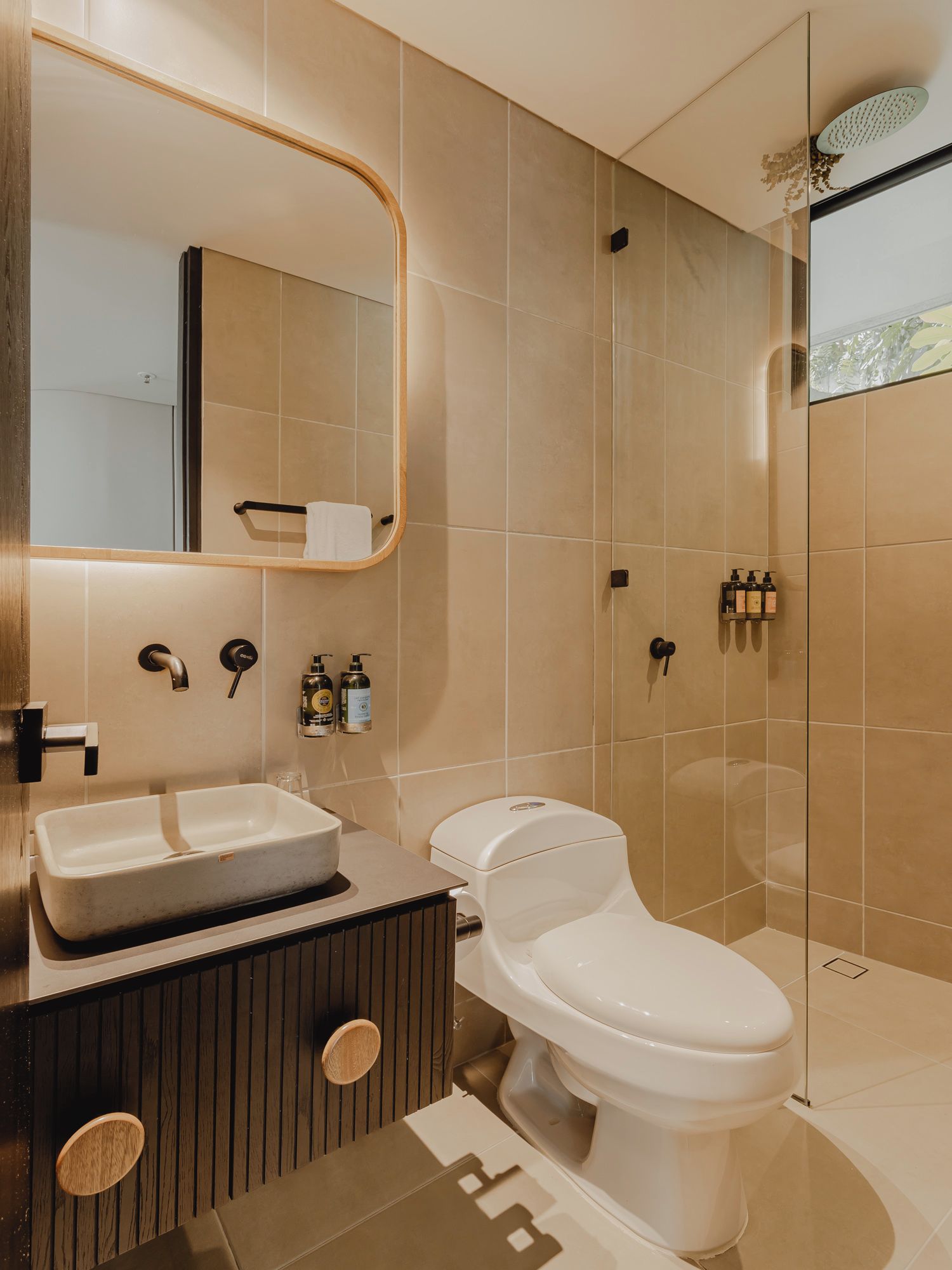 A modern bathroom with a large mirror, a sink, a toilet, and a shower area.