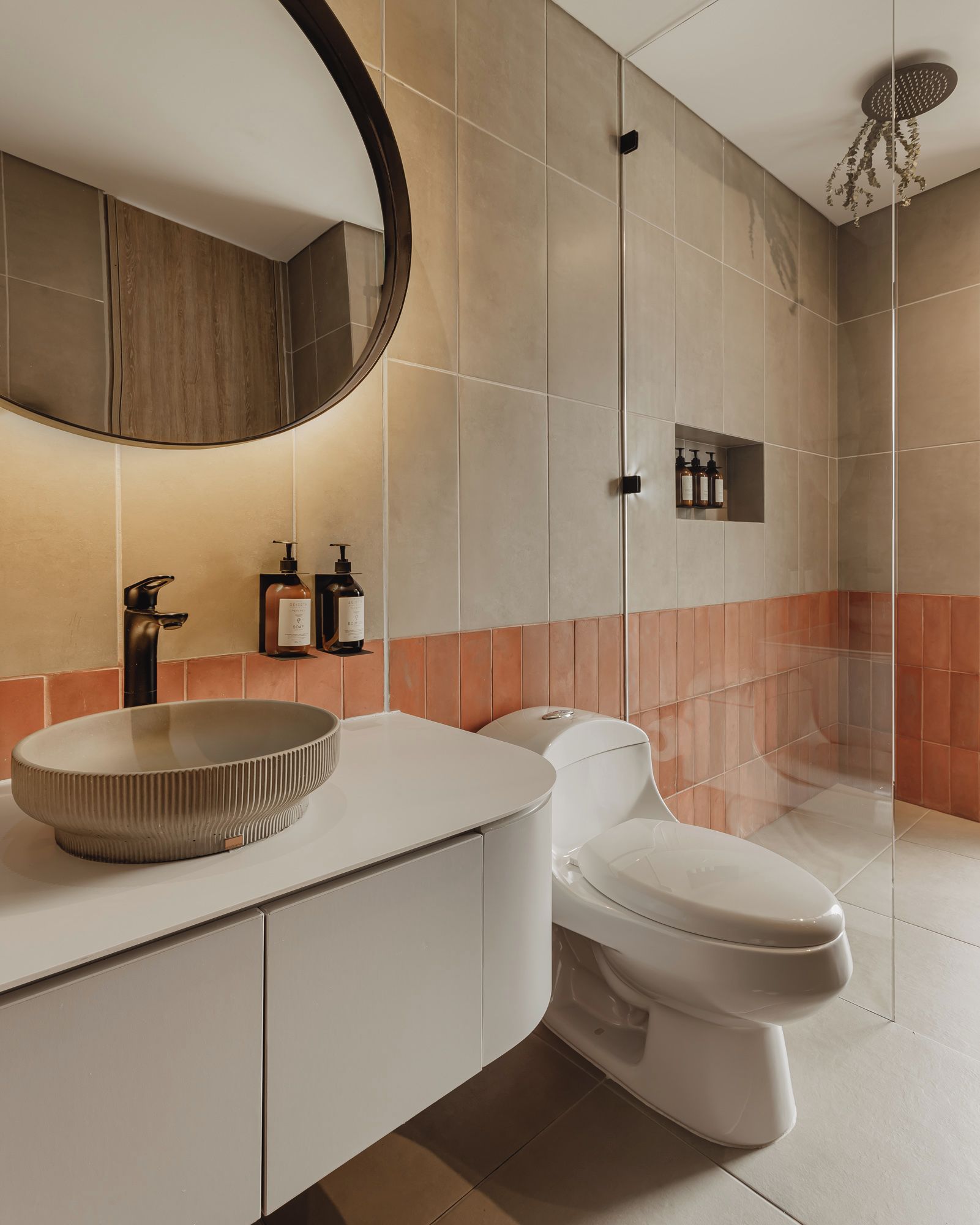 Ein modernes Badezimmer mit einem runden Waschbecken, einer Toilette und einer Duschkabine.