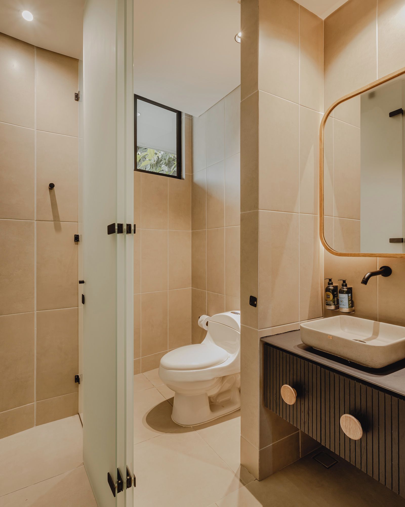 Un baño moderno con inodoro, lavabo y zona de ducha.