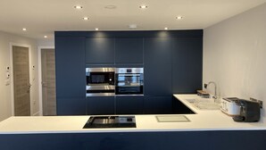 A modern kitchen with built-in appliances, a central island, and a sleek design. - 24 Breakwaters - Sandown Bay - Isle of Wight (Sandown)