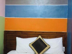 Restful retreat with a bed and a stylish headboard, complemented by a unique wall design.