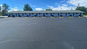 A motel with a row of rooms, a parking lot, and a clear blue sky. -  CB&M Duchesne Hotel (Duchesne)