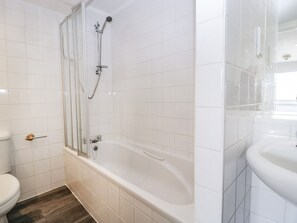 Une salle de bain équipée d’une baignoire, d’un espace douche et de toilettes.