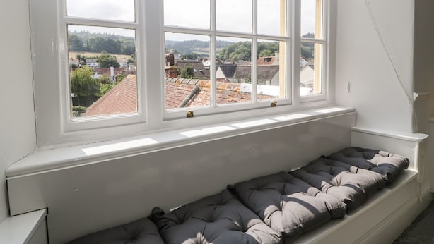 A room with a large window overlooking a town.