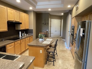A modern kitchen with granite countertops, wooden cabinets, and stainless steel appliances. - Spacious Townhome in North Scottsdale Grayhawk Gated Community (Scottsdale)