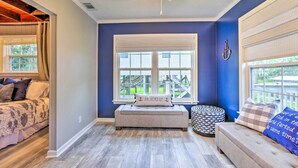 A room with a large window, a bench, a sofa, and a bed with patterned bedding. - Waterfront Home: Spectacular On-Site Fishing! (Panacea)