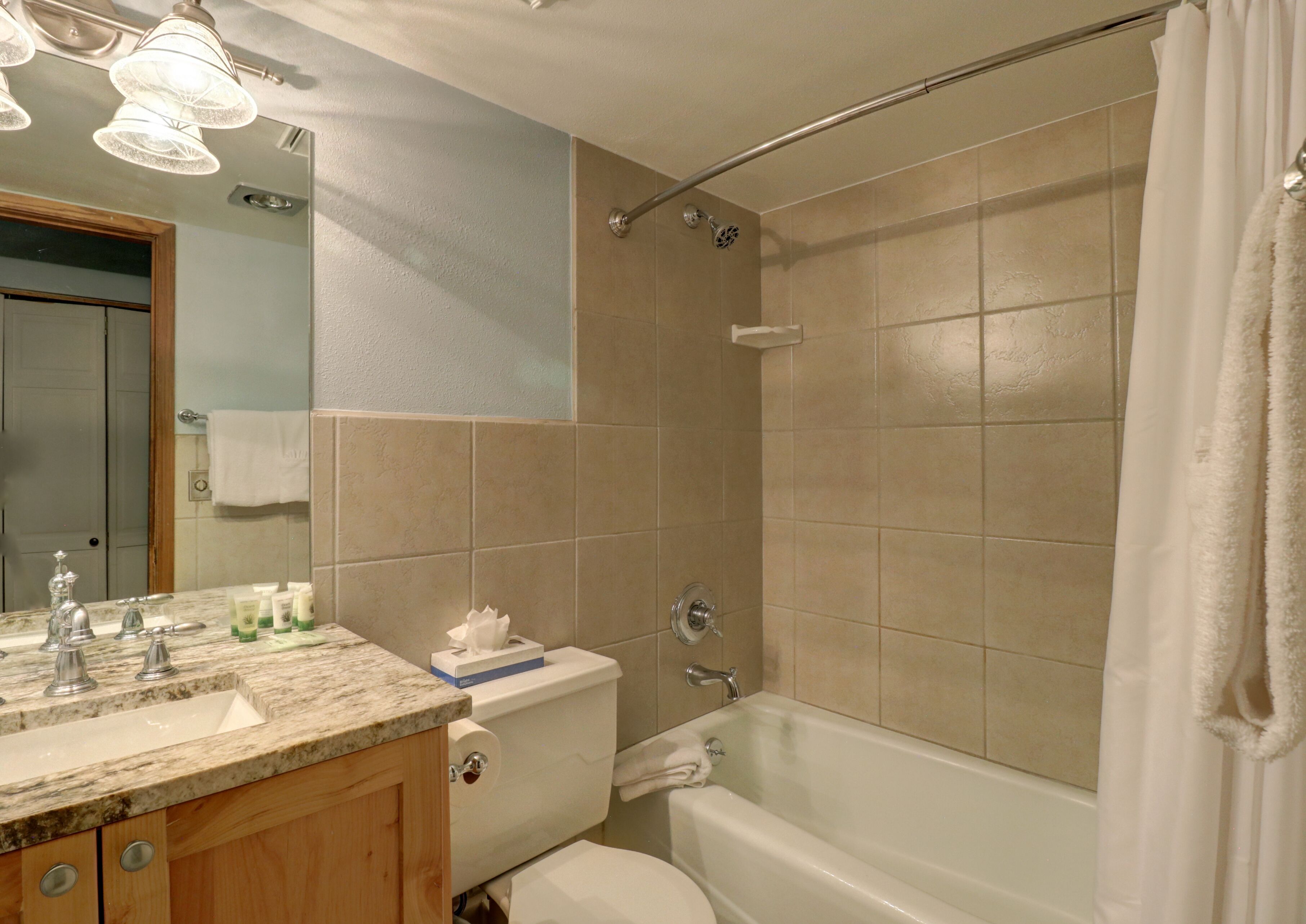 A bathroom with a shower, toilet, and sink.