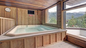 Ein Holzbott mit Blick auf Berge durch ein großes Fenster.