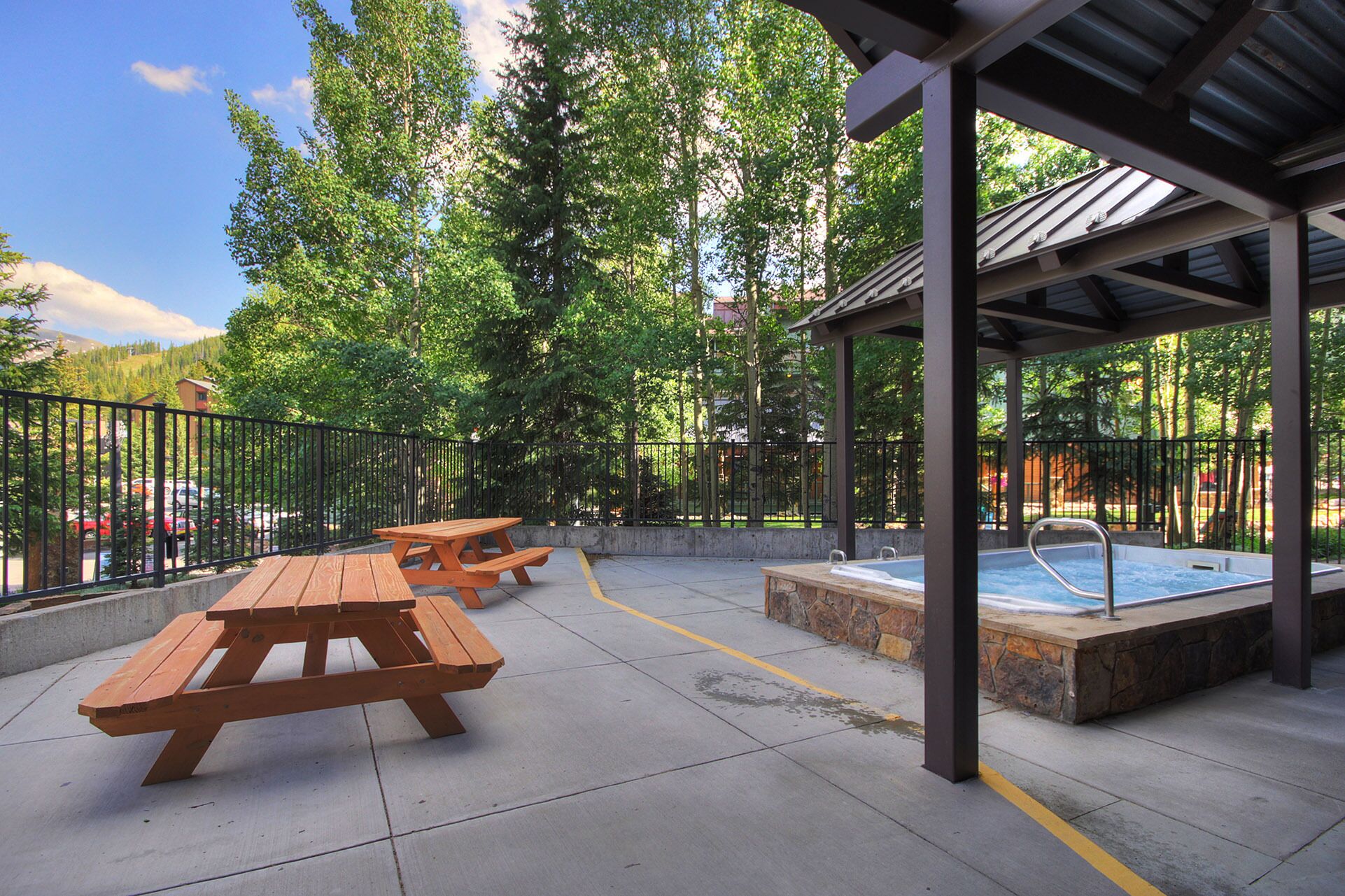 An outdoor patio area with picnic tables and a hot tub.