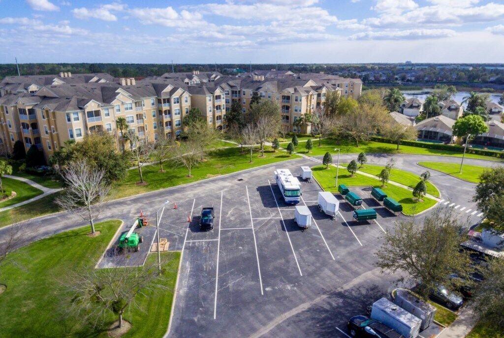 A multi-story apartment building with a parking lot in front.