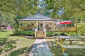 A small, two-story building with a porch and a red umbrella, surrounded by greenery. - 'The Creek' Winfield Gem: 73 Acres of Privacy (Winfield)